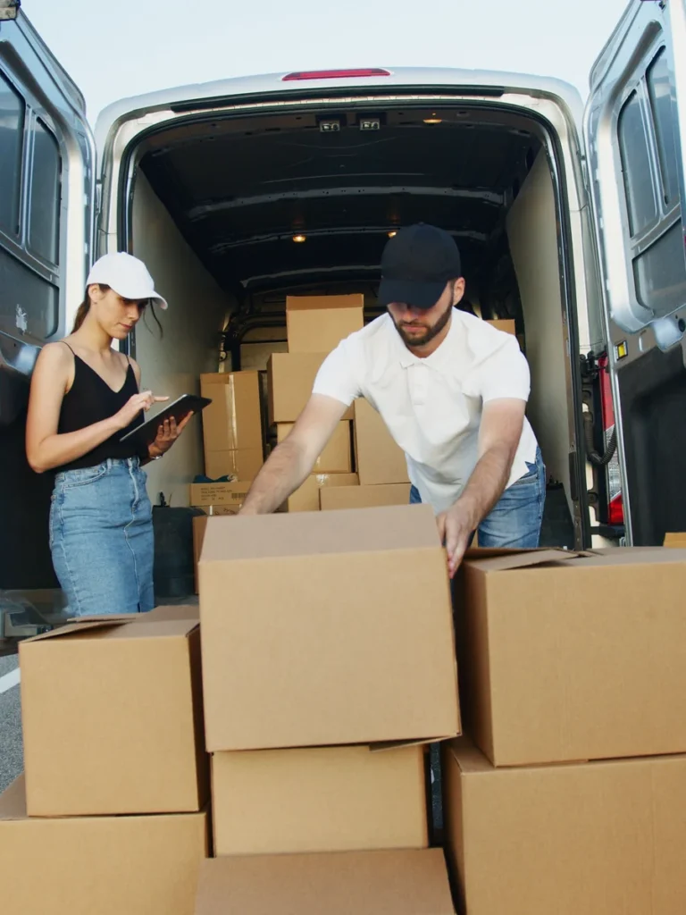 Dos operarios cargando cajas en una furgoneta
